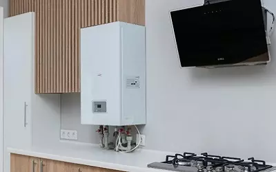 Calentador de agua instalado en cocina beige con muebles de madera